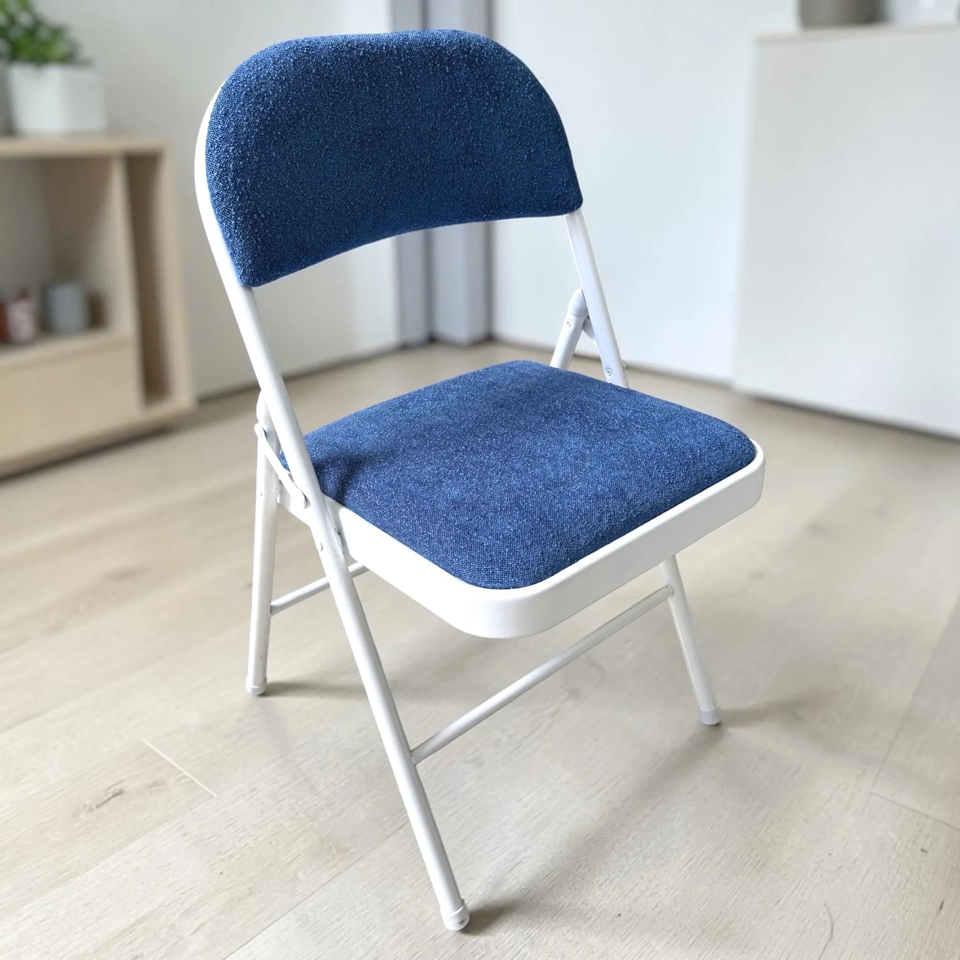 Silla plegable tapizada azul con estructura metálica blanca, modelo CH-3023-BLU, vista frontal en ángulo, Ambienta Home Decor.
