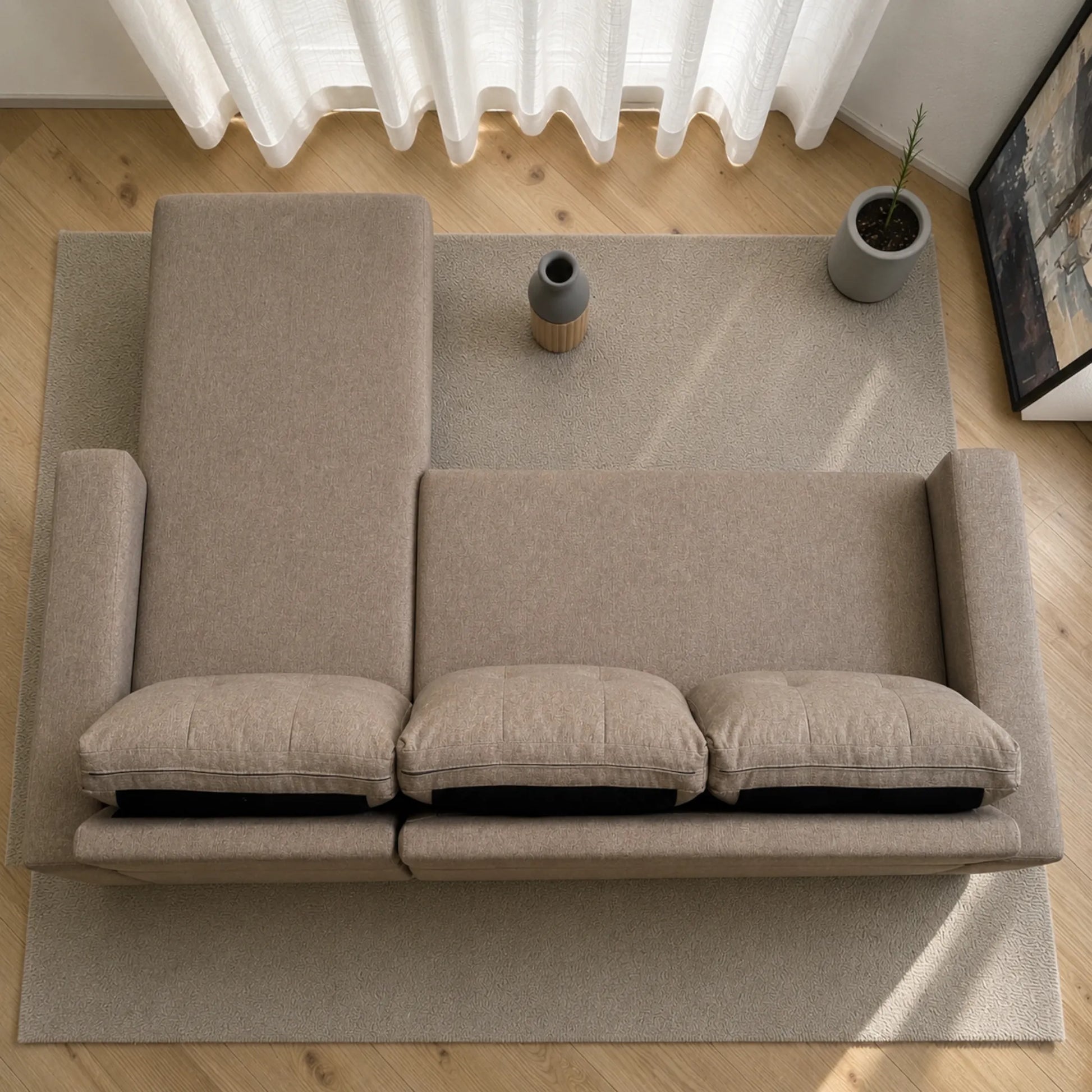 Vista superior del sofá cama 2 en 1 Ambienta Home Decor color taupe en configuración con chaise izquierda, tres cojines removibles, brazos rectos y diseño moderno sobre alfombra en sala contemporánea.