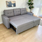 Sofá cama Ambienta Home Decor color gris claro con módulo deslizable parcialmente extendido, mecanismo metálico visible y chaise derecha en ambiente de sala contemporánea.