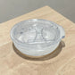 Tapa acrílica transparente removible para vaso térmico de 16 oz, vista lateral sobre mesa de madera.