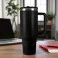 Termo de acero inoxidable negro con asa y tapa de rosca, capacidad 1200 ml, sobre escritorio en oficina.