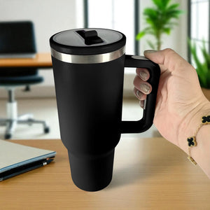 Termo de acero inoxidable color negro de 1200 ml con asa y tapa de rosca, sostenido en la mano en oficina.