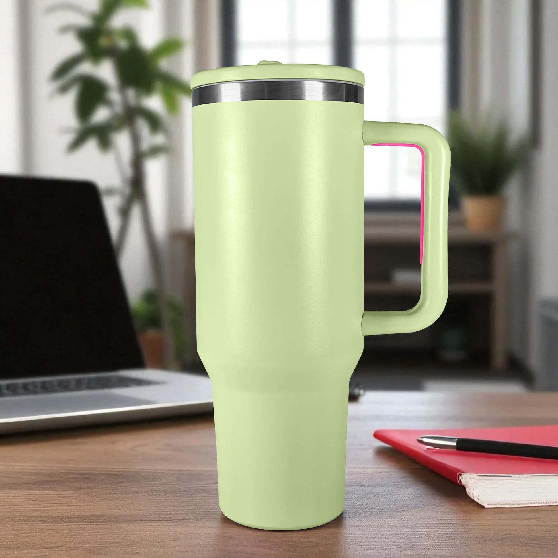 Termo de acero inoxidable color verde claro con asa y tapa de rosca, capacidad 1200 ml, sobre escritorio en oficina.