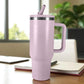 Vaso térmico de acero inoxidable color morado lila de 1200 ml con tapa y popote reutilizable, colocado en escritorio junto a cuaderno.